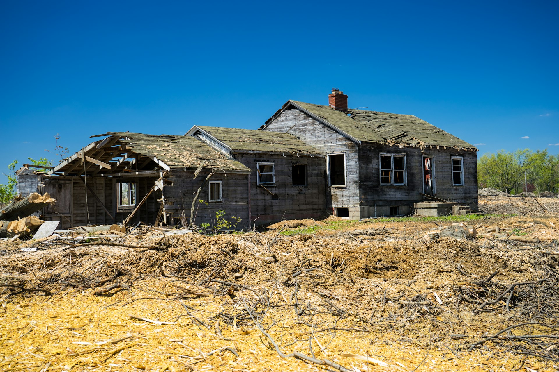 Older house with a collapsed roof section and structural damage