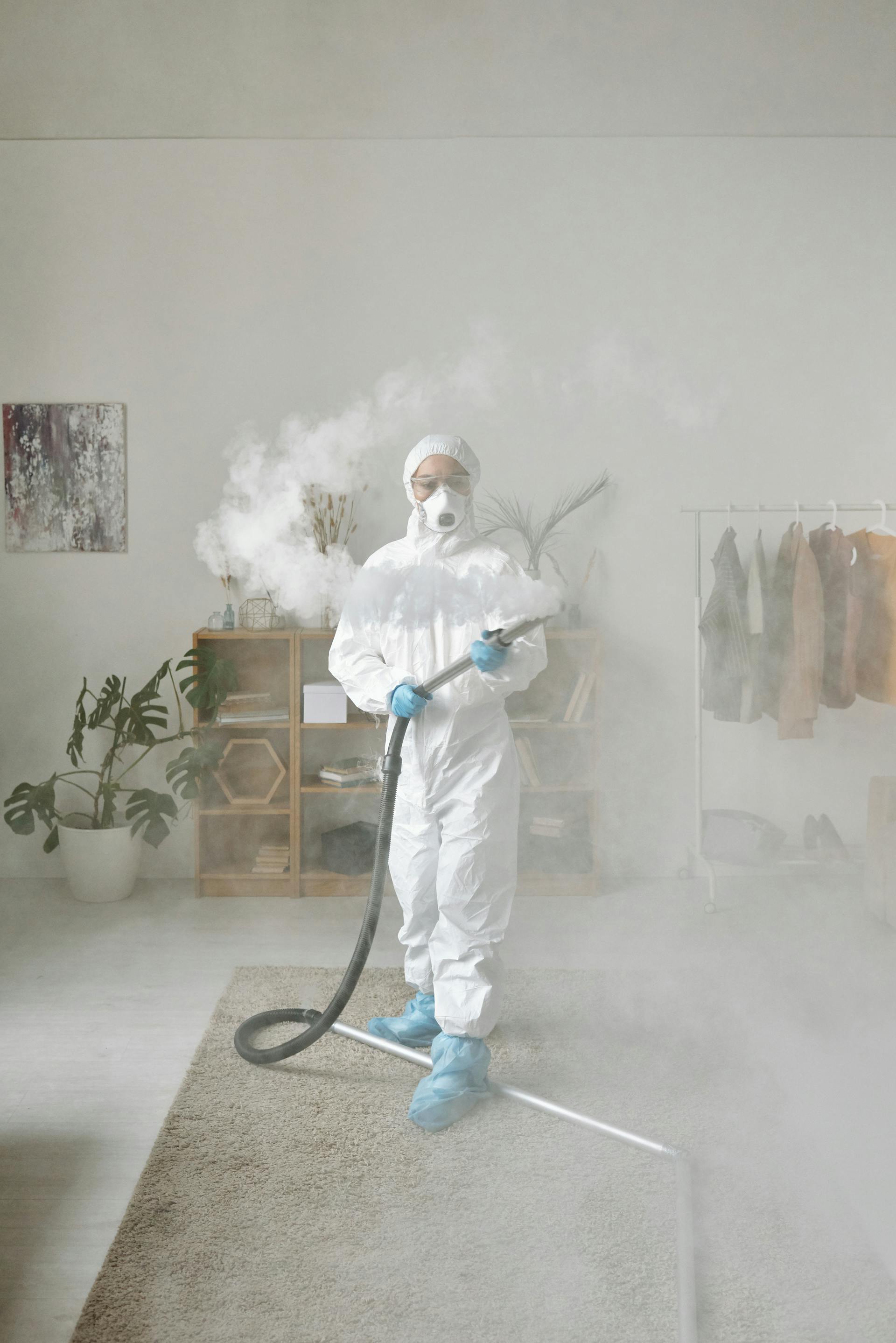Technician in a protective suit fogging a room