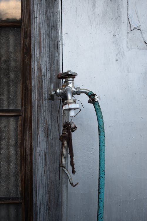 Garden hose connected to exterior hose bib on a BC home in spring