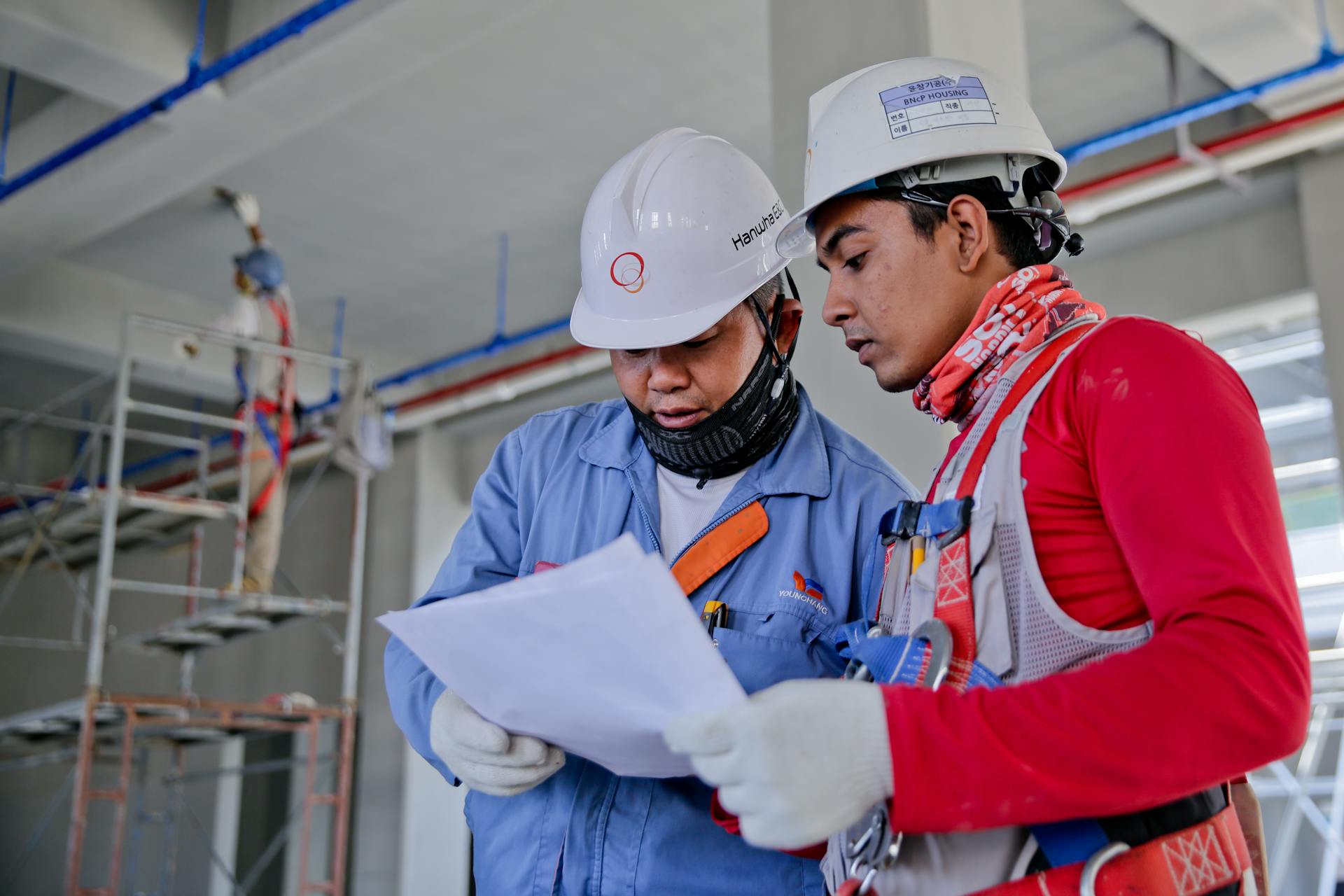Two workers reviewing a work plan on site